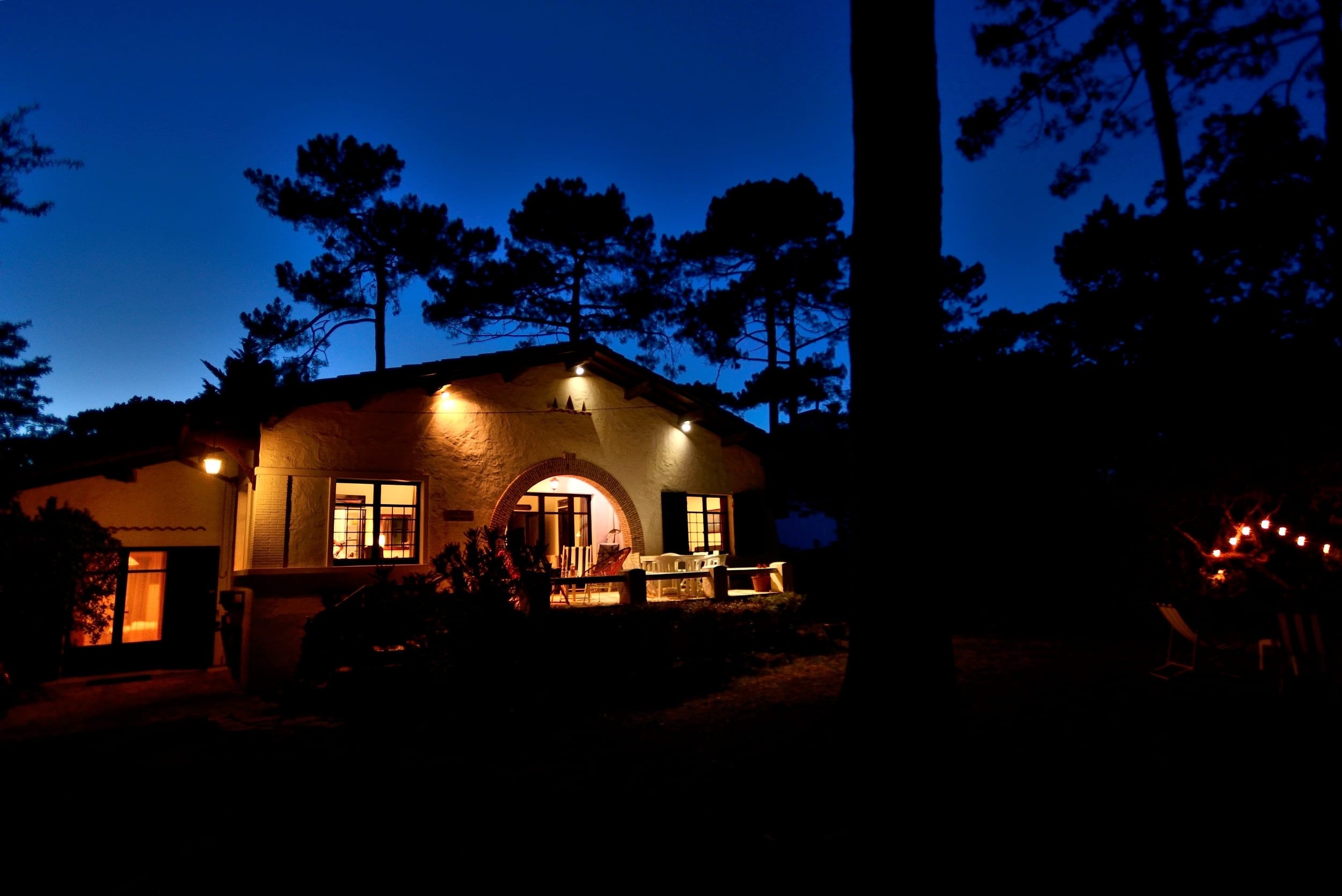 Vue au coucher de soleil de la façade de la Villa la Garrigue au Pyla, de la chambre 4, du jardin et du salon de jardin