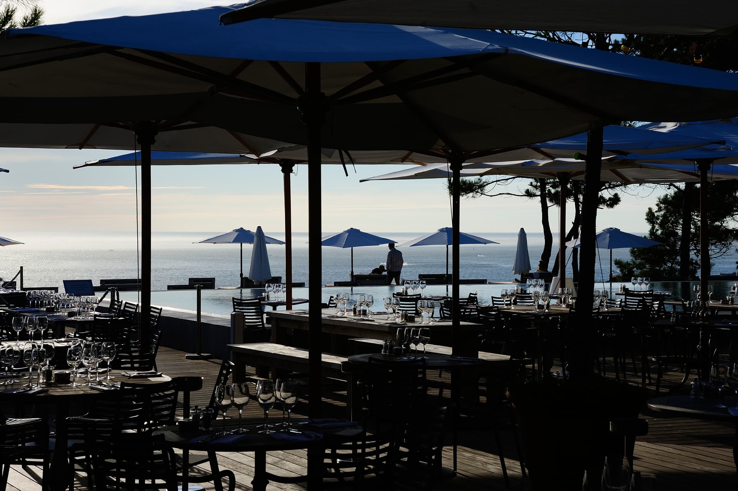 Les tables du restaurant Co(o)rniche avec vue sur la piscine de l'hôtel